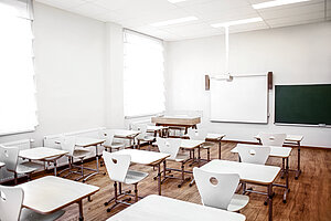 Ein leeres Klassenzimmer mit Stühlen.